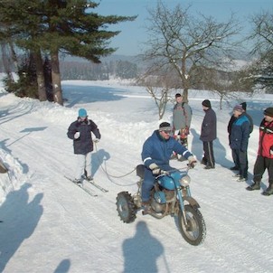 Zimní skierink na traktůrkách s lyžařem na laně