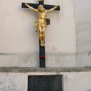 Kříž u kostelní zdi