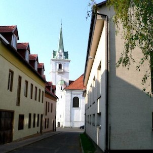 Pohled na věž kostelíčku v Trmicích z ulice Za humny