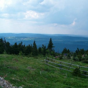 K Plešivci, Pohled na Plešivec (výrazná kupa uprostřed snímku) z Klínovce.