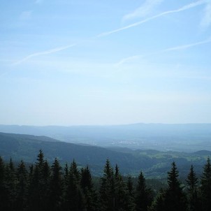 z rozhledny, přes svahy Krušných hor na Ostrov s Doupovskými horami na obzoru