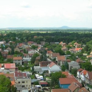 Pohled na rodinné domky s horou Říp v pozadí