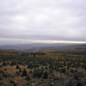 Panoramatický výhled na jihozápad, Pohled do Karolinina údolí v popředí, za ním údolí Lužce. Vlevo za krušnohorským svahem prosvítají Doupovské hory, vpravo výrazná Jelení hora. Nalevo od ní s notnou dávkou představivosti leží Klínovec a Fichtelberg, dva